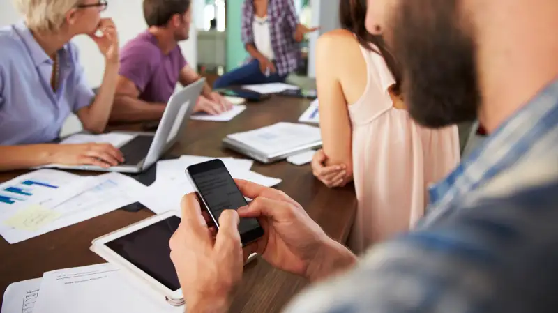 man texting during meeting