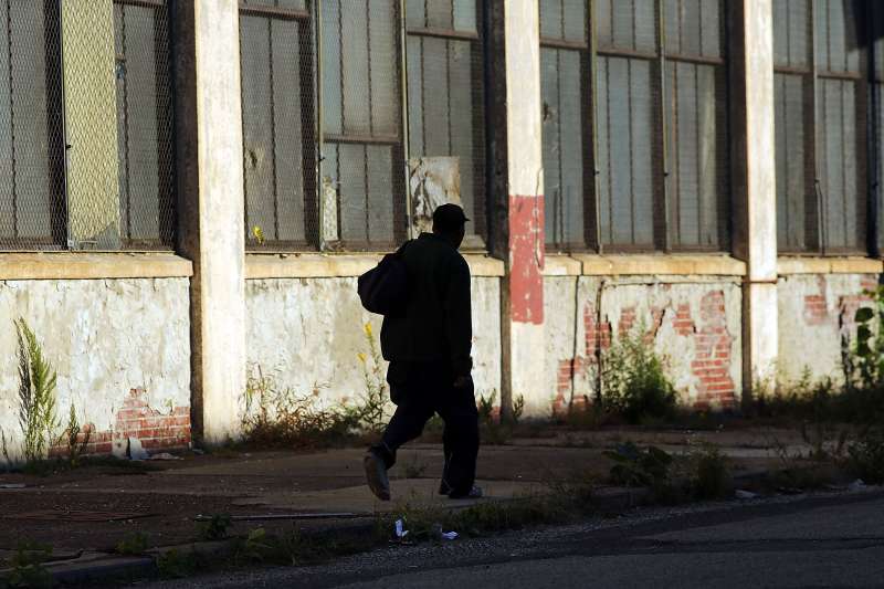 A man walks by a deserted factory on October 11, 2012 in Camden, New Jersey.