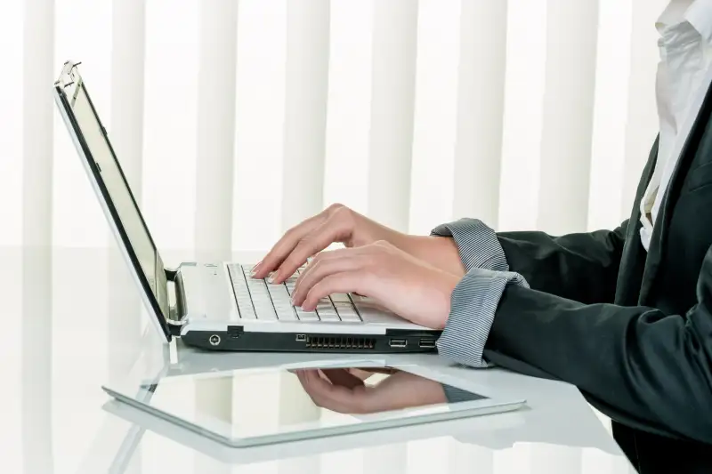 Frau im Büro mit Laptop Computer