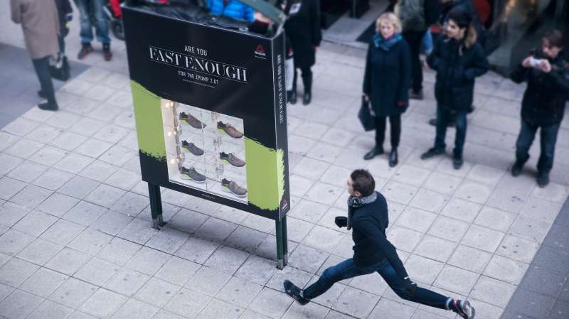 man running past reebok ad