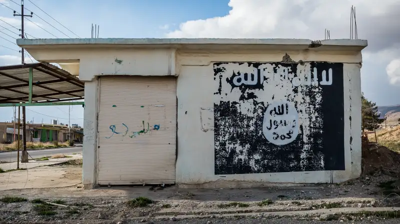 Ruins of Sinjar, Iraq with an ISIS/Daesh flag sign.