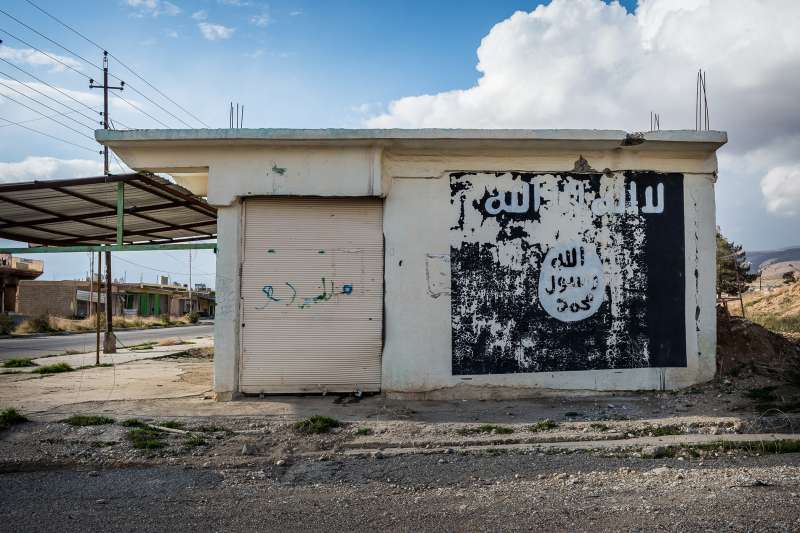 Ruins of Sinjar, Iraq with an ISIS/Daesh flag sign.