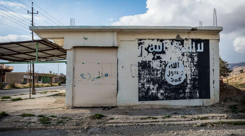 Ruins of Sinjar, Iraq with an ISIS/Daesh flag sign.