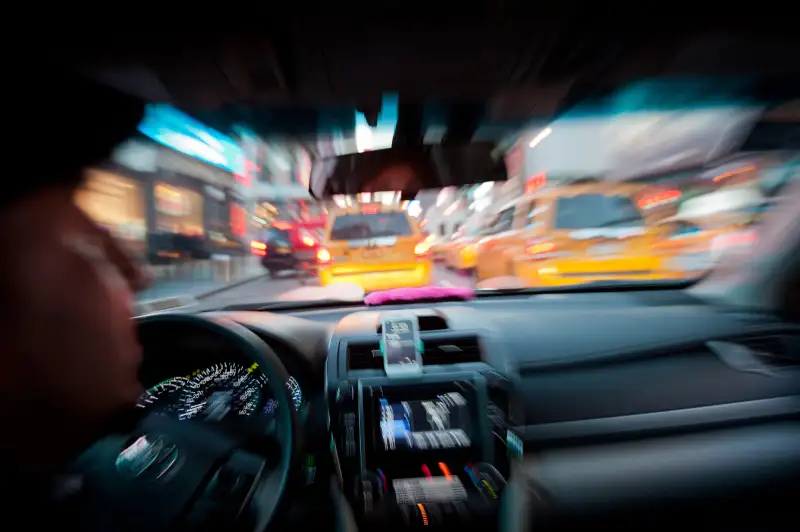 A pink mustache on the dashboard as Bouchaib El Hassani, 31, a Lyft driver, makes his way through midtown Manhattan, October 16, 2014.