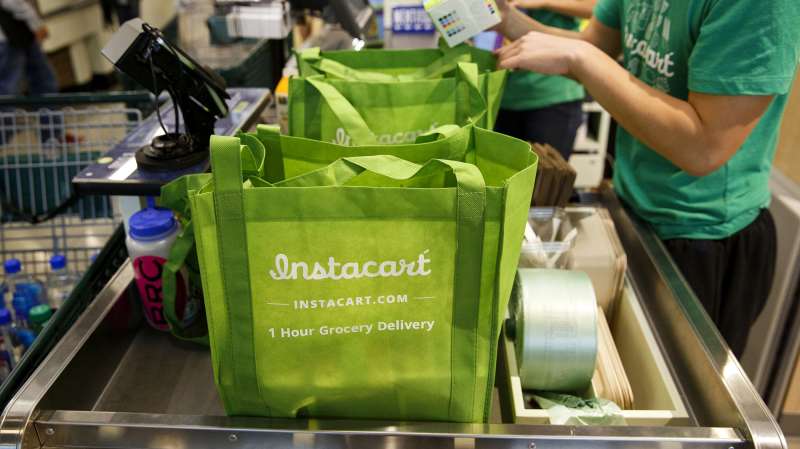 InstaCart employees fulfill orders for delivery at the new Whole Foods Market Inc. store in downtown Los Angeles, on November 9, 2015.