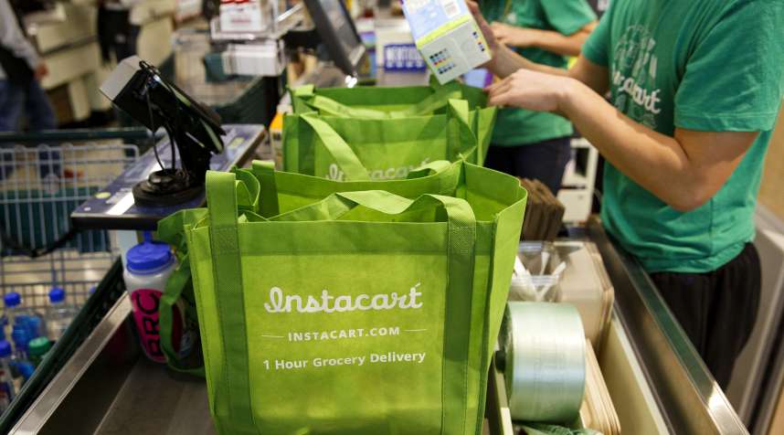 InstaCart employees fulfill orders for delivery at the new Whole Foods Market Inc. store in downtown Los Angeles, on November 9, 2015.