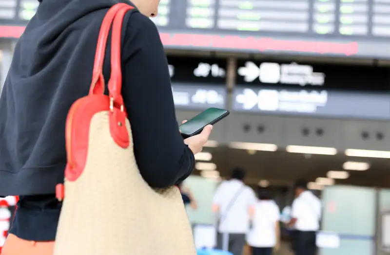 woman checking cell phone in airport