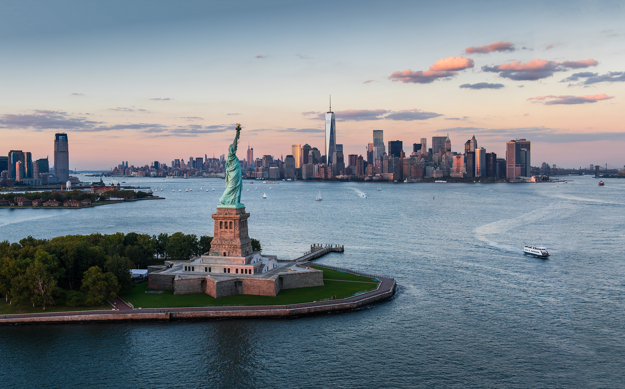 Aerial view of city with Statue of Liberty at sunset, New York