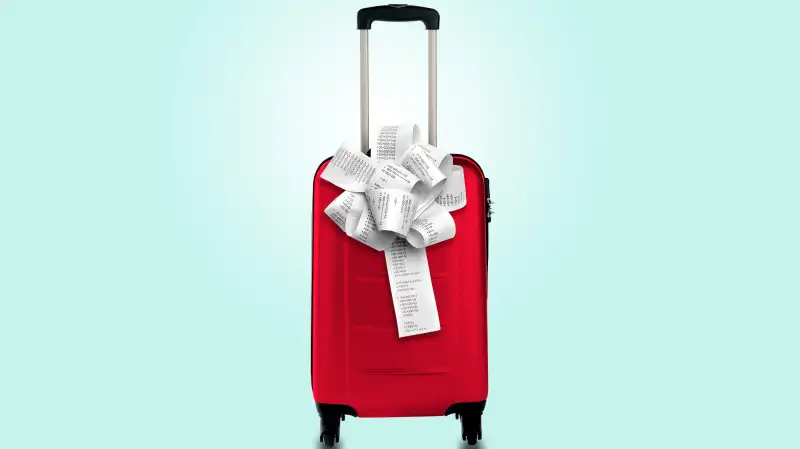 rolling suitcase with gift wrapped bow of receipt tape on it