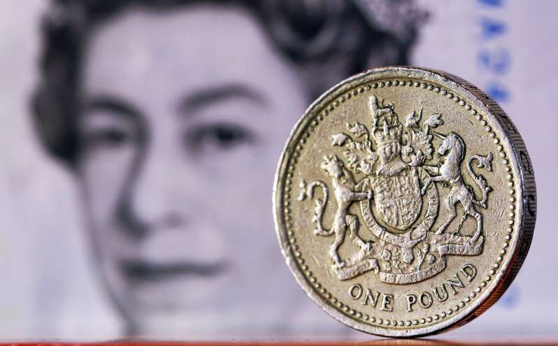 A one pound sterling coin sits in front of a British five pound banknote in this arranged photograph in London, U.K., on February 9, 2016. The pound has been falling versus the dollar since the middle of 2015 and accelerated its slide this year, reaching an almost seven-year low of $1.4080 on Jan. 21.