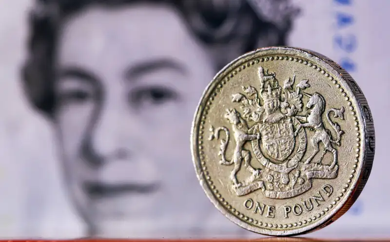 A one pound sterling coin sits in front of a British five pound banknote in this arranged photograph in London, U.K., on February 9, 2016. The pound has been falling versus the dollar since the middle of 2015 and accelerated its slide this year, reaching an almost seven-year low of $1.4080 on Jan. 21.