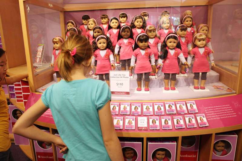 Girls look at dolls on display at the American Girl store in Los Angeles.
