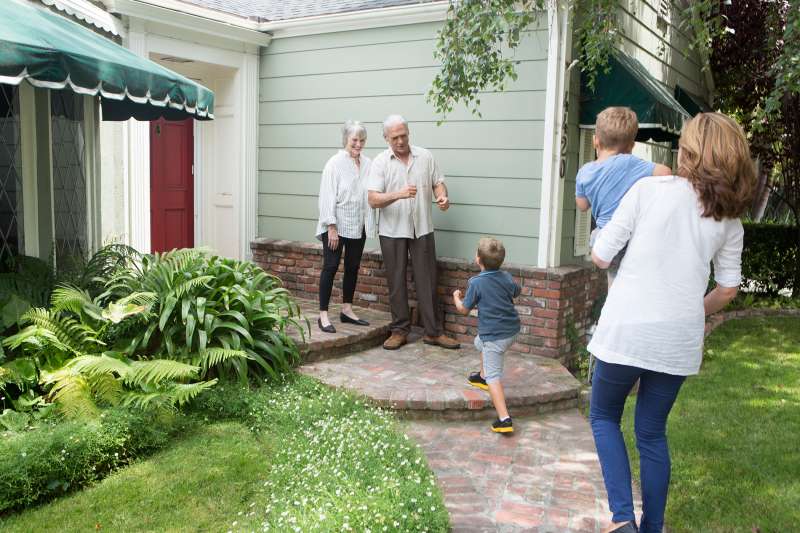 woman and kids running up to retired parents' house