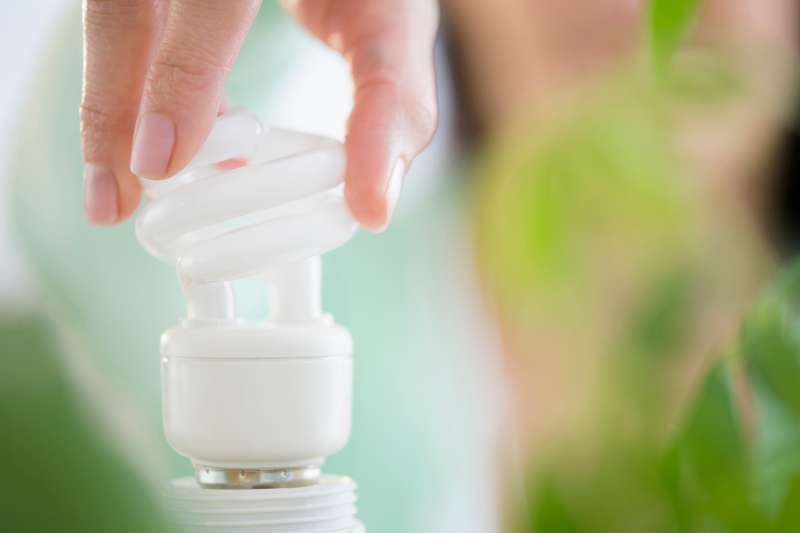 person screwing in energy saving bulb
