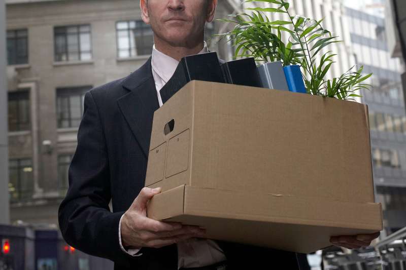 businessman carrying box of personal items from office