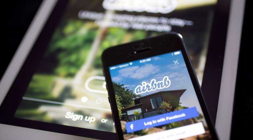 The Airbnb Inc. application is displayed on an Apple Inc. iPhone and iPad in this arranged photograph in Washington, D.C., on March 21, 2014. Airbnb Inc. is raising money from investors including TPG Capital in a financing round that would value the room-sharing service at more than $10 billion, said people with knowledge of the deal.