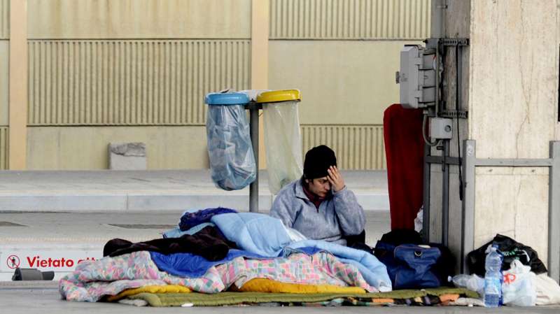 A homeless man sleeps at Bologna main railway station, Bologna, Italy, December 31, 2015.
