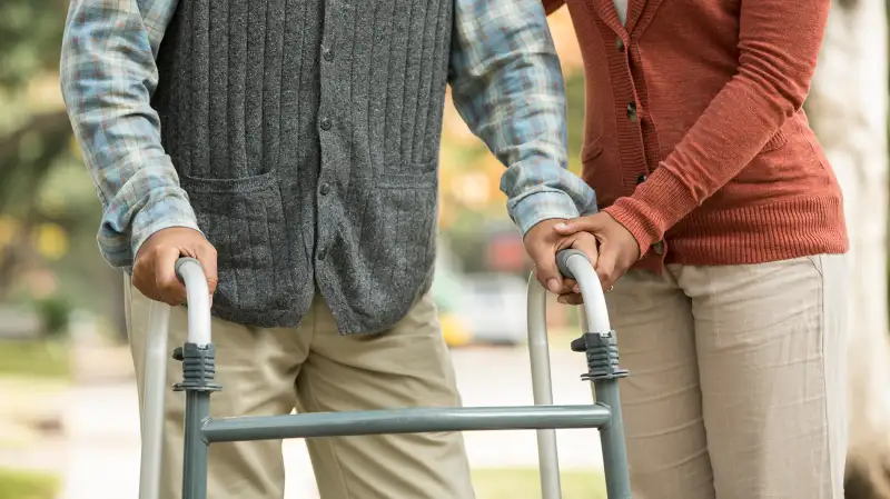 person helping man with walker