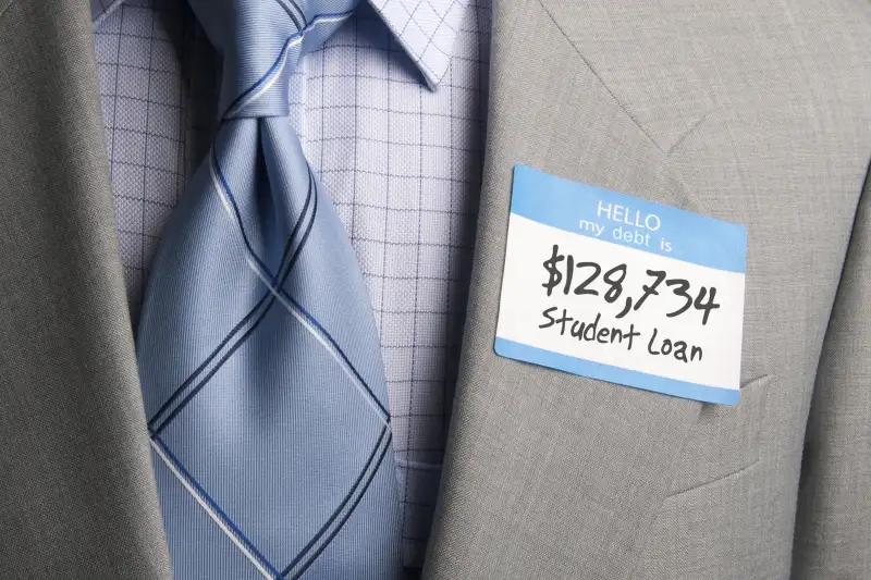 man in suit wearing hello my debt is....$128,734 Student Loan sticker