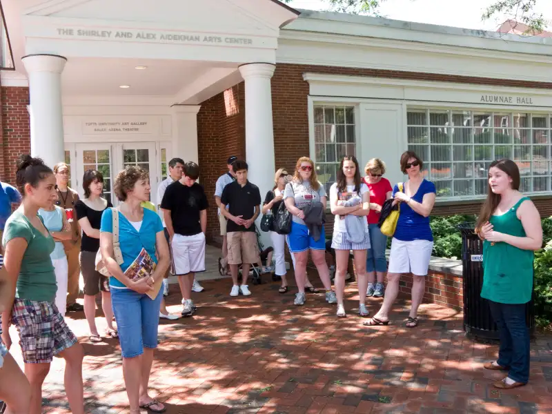 Parents and prospective students on student-led admissions office tour of Tufts University crossing campus.