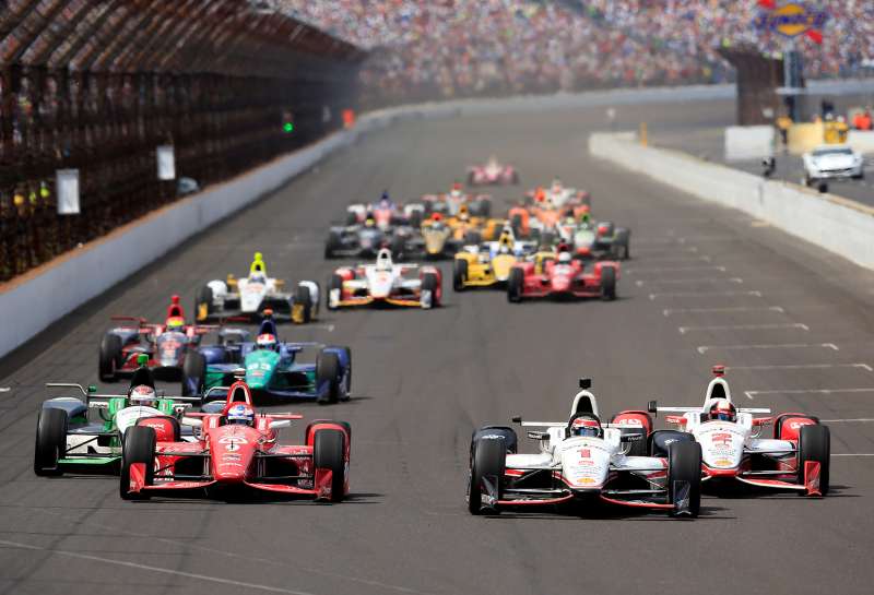 Scott Dixon of Australia, driver of the #9 Target Chip Ganassi Racing Chevrolet Dallara, races alongside Juan Pablo Montoya of Columbia, driver of the #2 Team Penske Chevrolet Dallara, and Will Power of Australia, driver of the #1 Verizon Team Penske Chevrolet Dallara, after a restart during the 99th running of the Indianapolis 500 at Indianapolis Motorspeedway on May 23, 2015 in Indianapolis, Indiana.