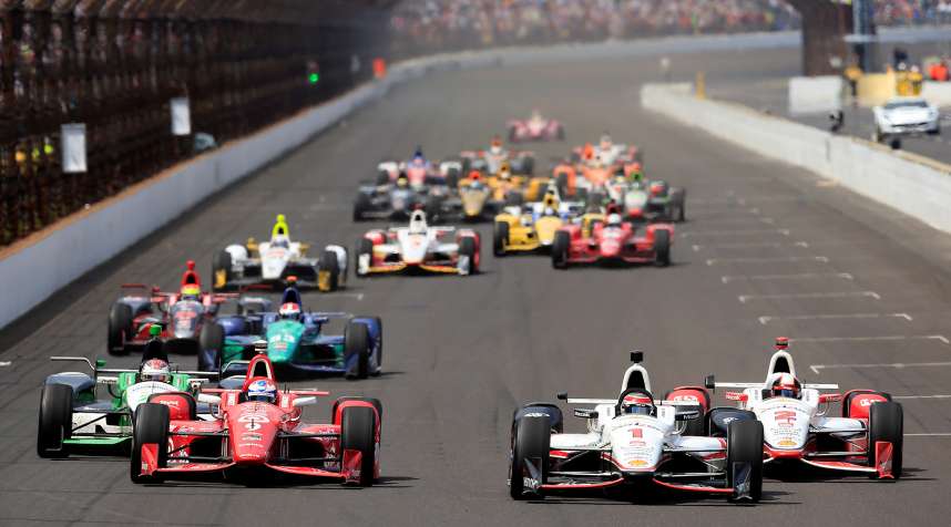 Scott Dixon of Australia, driver of the #9 Target Chip Ganassi Racing Chevrolet Dallara, races alongside Juan Pablo Montoya of Columbia, driver of the #2 Team Penske Chevrolet Dallara, and Will Power of Australia, driver of the #1  Verizon Team Penske Chevrolet Dallara, after a restart during the 99th running of the Indianapolis 500 at Indianapolis Motorspeedway on May 23, 2015 in Indianapolis, Indiana.