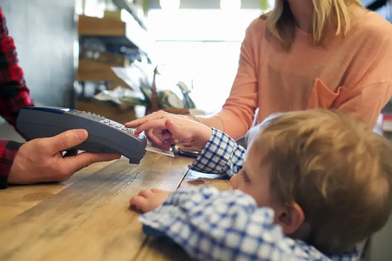 Boy using credit card machine in store
