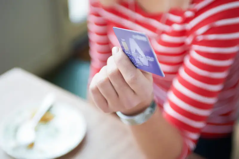 close up of woman paying with credit card at cafe