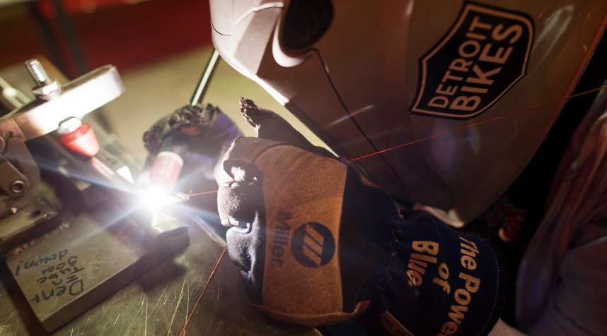 A worker tack welds parts of a bicycle frame together at the Detroit Bikes manufacturing facility in Detroit, Michigan, U.S., on Thursday, June 25, 2015.