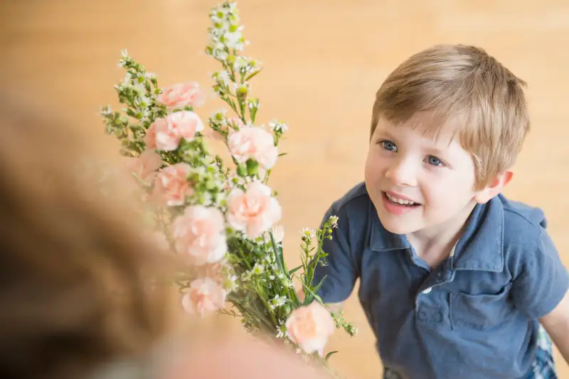 Boy giving bouquet flowers to Mother
