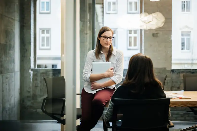 Two businesswomen in a modern office talking