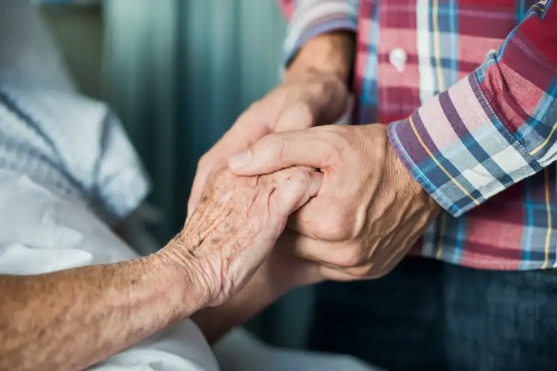 Close up of son holding his mothers hands