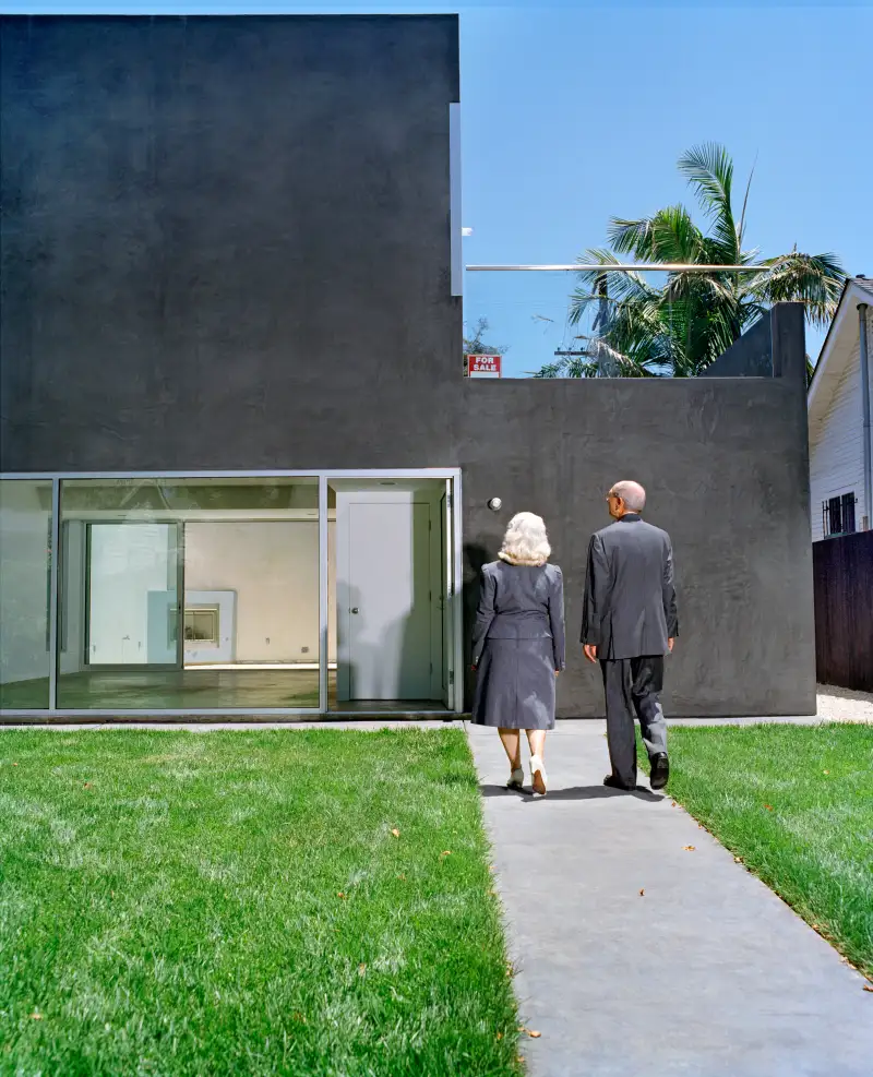 Mature couple walking towards gray house