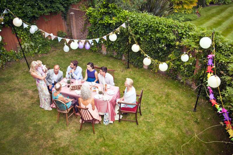 High angle view of family and friends around table at garden party