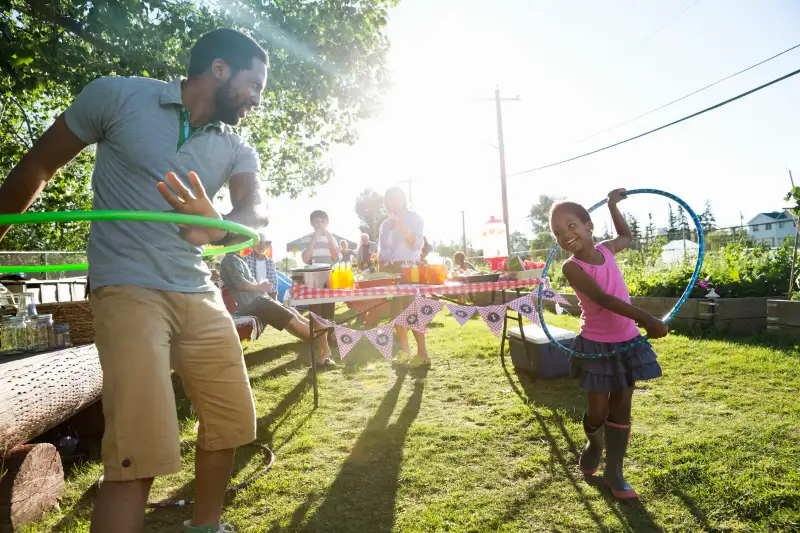Father and daughter spinning in plastic hoops park