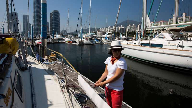 A woman holds a rope as a yacht leaves the Marina in the Haeundae district in Busan, South Korea, on July 31, 2015.