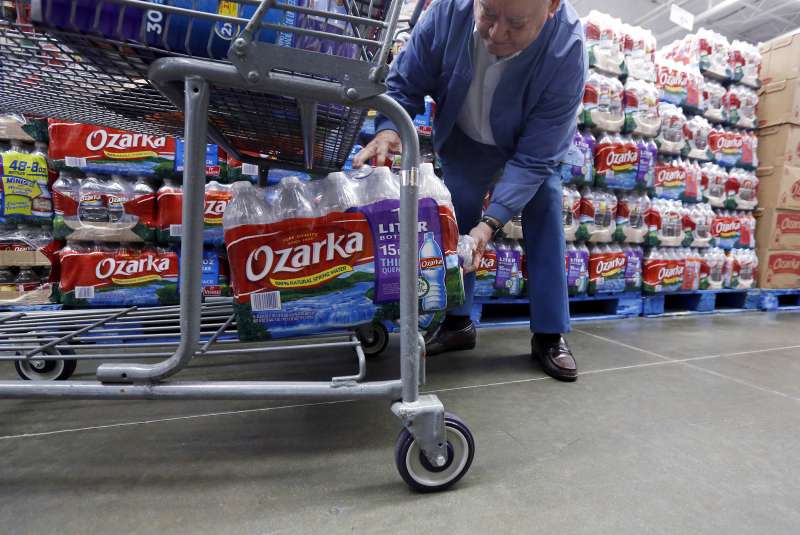 In this March 5, 2013 photo, Walter Pugh, 83, of Belzoni, Miss., loads a case of his bottled water into his shopping cart in Jackson, Mississippi.
