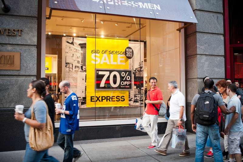 Shoppers in the Herald Square shopping district in New York pass an Express store advertising its end of season sale.