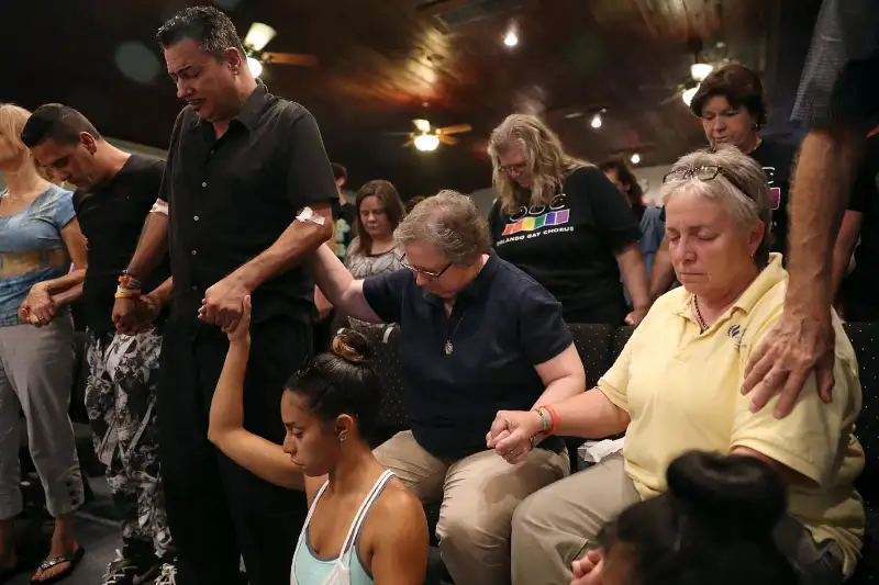 Orlando, second from left, who was injured in the mass shooting at Pulse but did not want his last name used, attends a memorial service at the Joy MCC Church for the victims of the Orlando nightclub shooting.