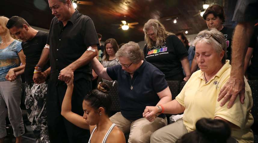 Orlando, second from left, who was injured in the mass shooting at Pulse but did not want his last name used, attends a memorial service at the Joy MCC Church for the victims of the Orlando nightclub shooting.