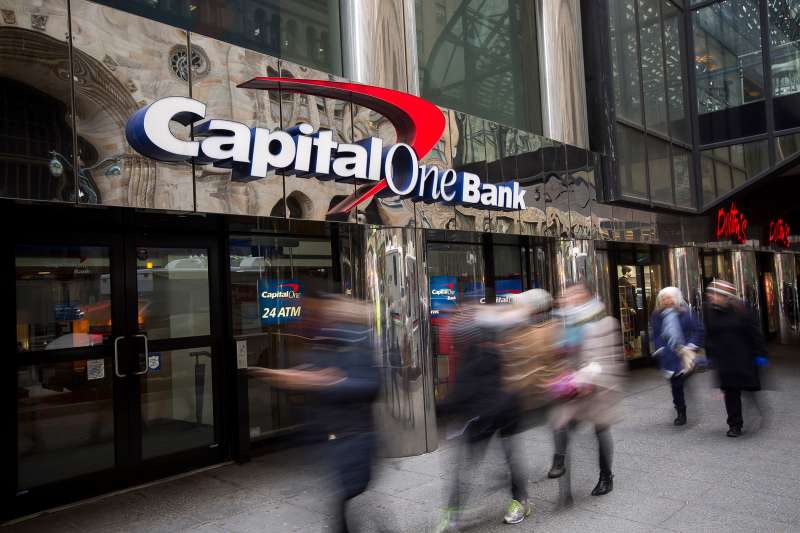 Pedestrians walk past a Capital One bank branch in New York, on January 22, 2016.