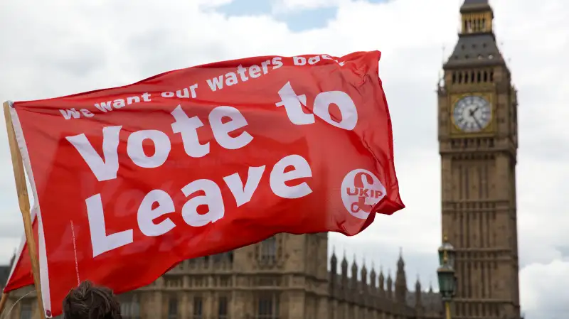 Leave supporters hold flags as they stand on Westminster Bridge during an EU referendum campaign stunt in which a flotilla of boats supporting Leave sailed up the River Thames outside the Houses of Parliament in London, Wednesday, June 15, 2016. A flotilla of boats protesting EU fishing polices has sailed up the River Thames to the Houses of Parliament as part of a campaign backing Britain's exit from the European Union. The flotilla was greeted by boats carrying remain supporters.