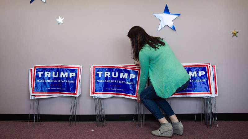 A campaign worker organizes campaign signs to be given out at the opening of the Donald Trump for President Raleigh campaign headquarters, in Raleigh, N.C., March 5, 2016.