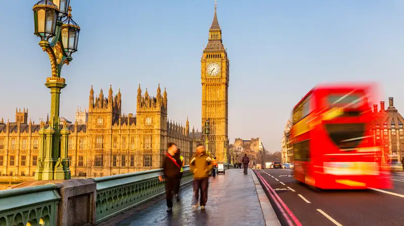 Red double-decker bus passing Big Ben, London