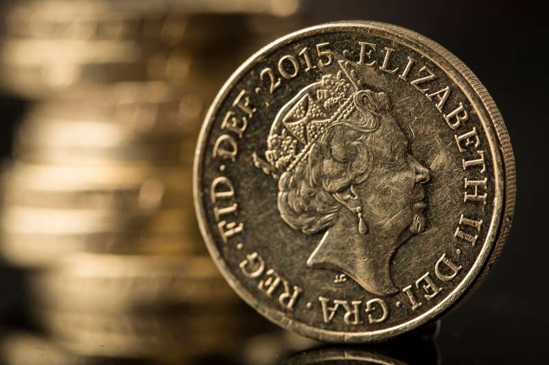 A British one pound sterling coin stands in front of a stack of one pound sterling coins in this arranged photograph in Guildford, U.K., on Monday, June 13, 2016. Sterling swung on Monday as anxiety about Britains referendum on staying or leaving the European Union continued to build.