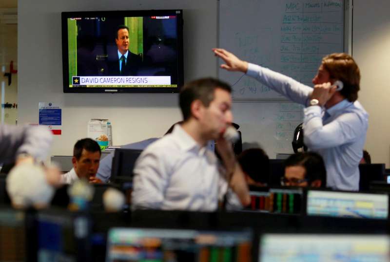 A TV shows the resignation of Britain's Prime Minister David Cameron as traders from BGC, a global brokerage company in London's Canary Wharf financial centre react after European stock markets opened June 24, 2016 after Britain voted to leave the European Union in the EU BREXIT referendum.