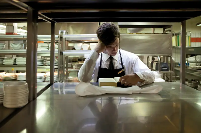 Waiter reading a book