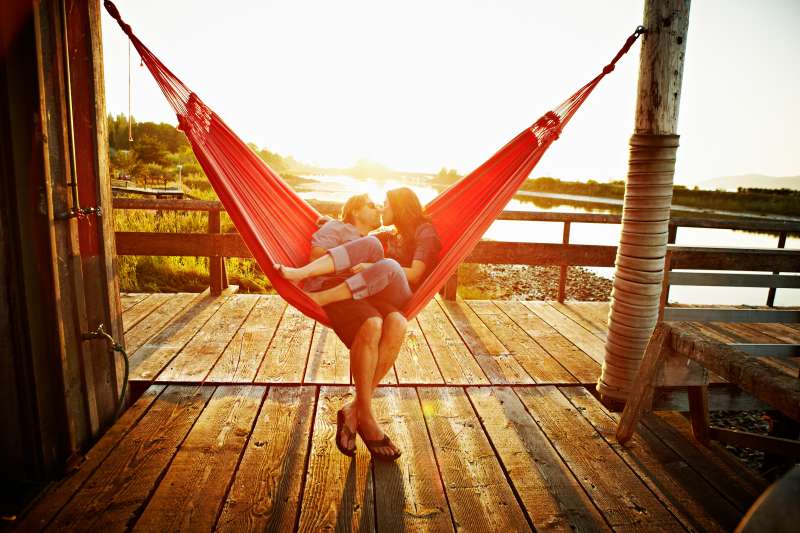 Husband and wife couple kissing in hammock