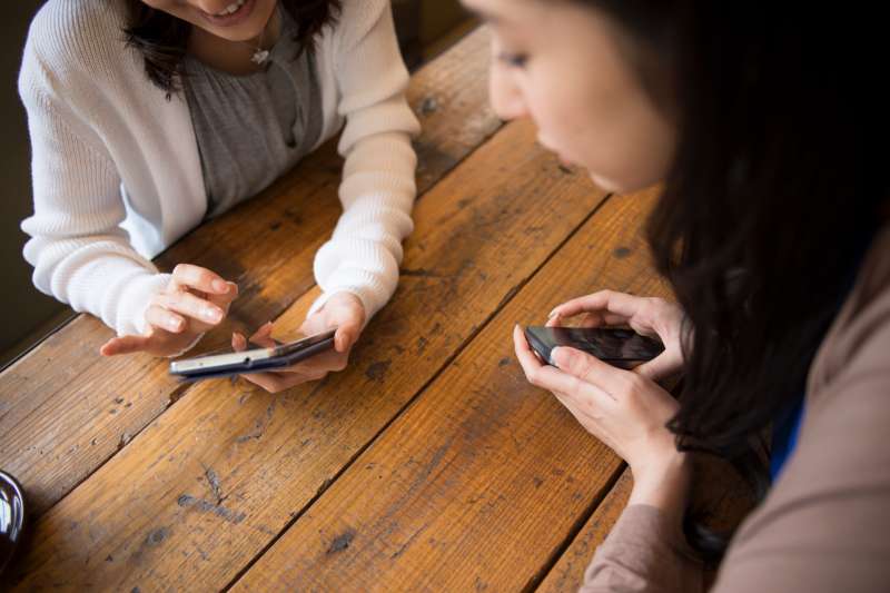 friends talking with smartphones at  cafe