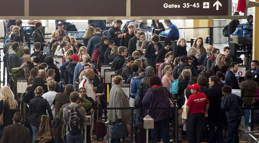 Passengers stand in line to go through a TSA security checkpoint as they head to their flights at Reagan National Airport in Arlington, Virginia.
